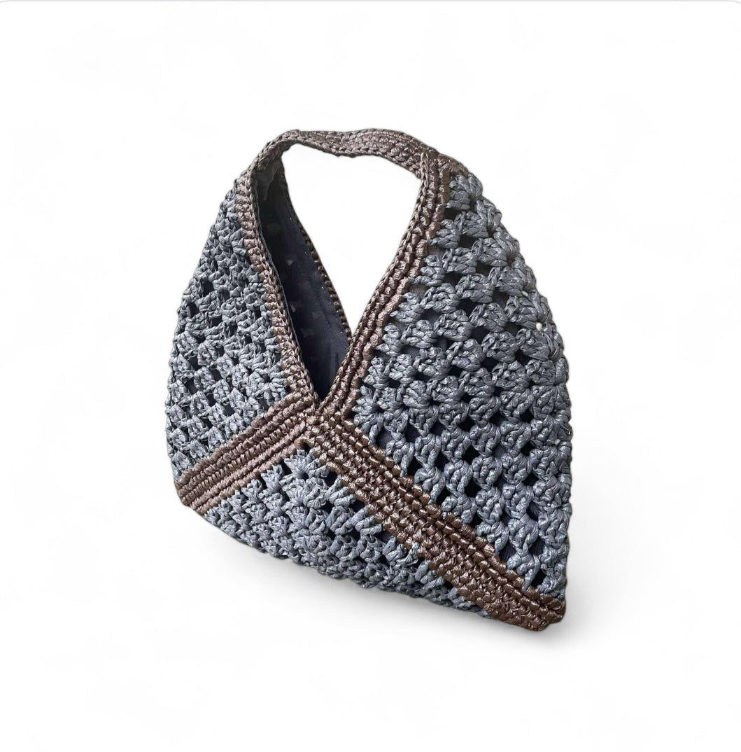 Crocheted bag with greyand brown pattern on a white background